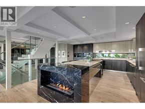 Lions Bay apartment for rent - A modern kitchen with a marble fireplace and wooden floors.
