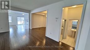 Southgate apartment for rent - A spacious room with wooden floors and white walls, with a bathroom visible in the background.