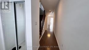 Southgate apartment for rent - A hallway with a glass door on the left and a light at the end.
