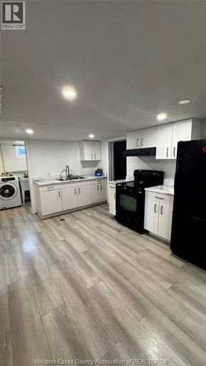 Windsor apartment for rent - A kitchen with black and white appliances and wooden floors.