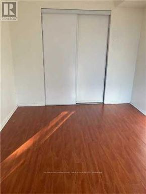 Toronto (Eglinton East) condo for rent - A room with a wooden floor and a white door.