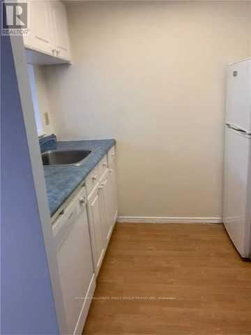 Toronto (Eglinton East) condo for rent - A kitchen with white cabinets and a blue countertop.