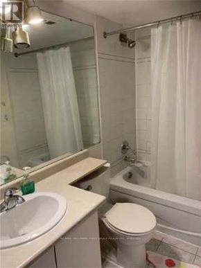 Toronto (Eglinton East) condo for rent - A white toilet sits next to a white sink in a bathroom.