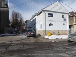 Halton Hills (Georgetown) apartment for rent - A car is parked on the street in front of a white building.