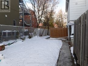 Halton Hills (Georgetown) apartment for rent - A snow-covered yard with a fence and a building in the background.