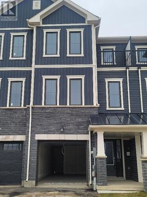 Brantford townhouse for rent - A blue house with a black garage door.