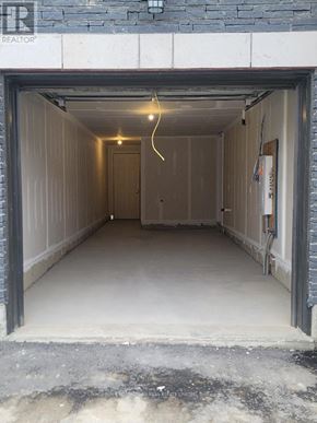 Brantford townhouse for rent - A large, empty garage with a single light hanging from the ceiling.