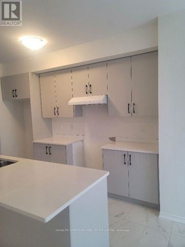 Brantford townhouse for rent - A kitchen with white cabinets and a counter top.