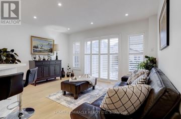 Mississauga (Churchill Meadows) apartment for rent - A living room with a brown leather couch, a wooden coffee table, and a painting on the wall.