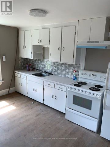 Welland (Welland Downtown) multi-family for rent - A kitchen with white appliances and cabinets.
