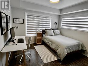 Collingwood condo for rent - A bedroom with a bed, desk, and chair.