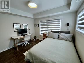 Collingwood condo for rent - A bedroom with a bed, desk, and window with blinds.