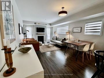 Collingwood condo for rent - A well-lit, modern living room with a fireplace and a dining table set for four.