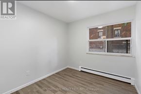 Hamilton (Stinson) multi-family for rent - A room with a window showing a view of a building outside.