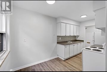 Hamilton (Stinson) multi-family for rent - A white kitchen with a stove and cabinets.