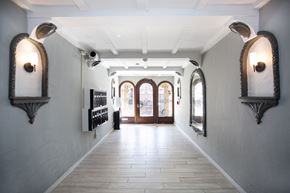 San Francisco apartment for rent - A long hallway with arched windows and lights on the wall.