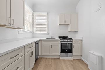 San Francisco apartment for rent - A modern kitchen with a stove top oven and wooden floors.