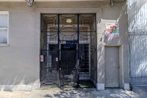 San Francisco apartment for rent - A metal gate with a spider web design is in front of a building.