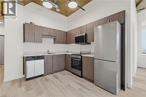 Kitchener condo for rent - A kitchen with a refrigerator, oven, and microwave.