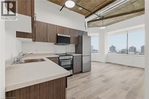Kitchener condo for rent - A kitchen with wooden cabinets and a stainless steel oven.