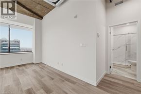 Kitchener condo for rent - A room with a window overlooking a building with the logo REALTOR on the top left.