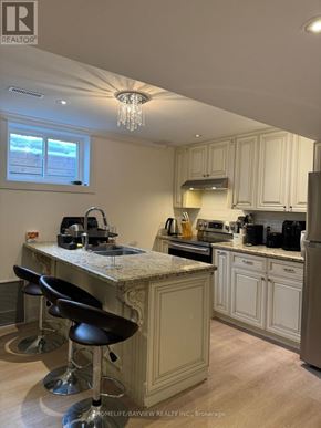 Richmond Hill (South Richvale) apartment for rent - A kitchen with a marble countertop and bar stools.