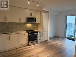 Toronto (Willowdale West) condo for rent - A kitchen with white cabinets and a black microwave above the stove.