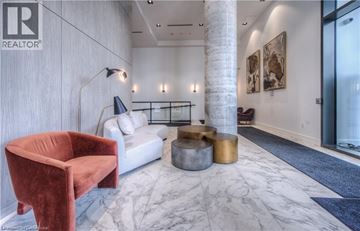 Kitchener condo for rent - A living room with a red chair and a white couch.