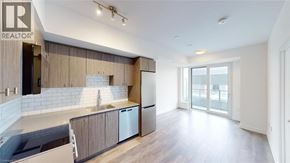 Kitchener condo for rent - A modern kitchen with wooden cabinets and a large island.