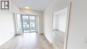 Kitchener condo for rent - A spacious room with a sliding glass door leading to a balcony.