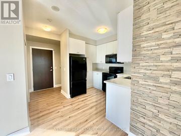 Toronto (Agincourt South-Malvern West) condo for rent - A kitchen with a black fridge and stove top oven.
