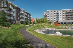 Renfrew condo for rent - A real estate photo of apartment buildings with a pond in the foreground.