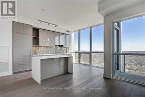 Toronto (Annex) condo for rent - A modern kitchen with a large island and a view of the outdoors.