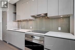 Toronto (Annex) condo for rent - A modern kitchen with stainless steel appliances and white cabinets.
