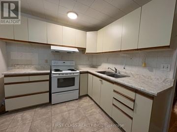 Toronto (East End-Danforth) apartment for rent - A kitchen with white cabinets and a marble countertop.