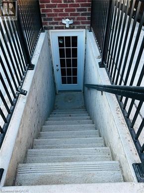Kitchener apartment for rent - A set of stairs leading to a door at the bottom of a stairwell.