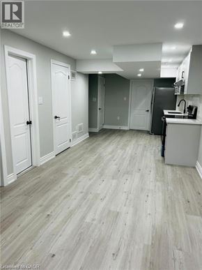 Kitchener apartment for rent - A kitchen with white cabinets and a wooden floor.