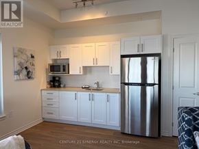 Ottawa apartment for rent - A kitchen with white cabinets and a stainless steel refrigerator.