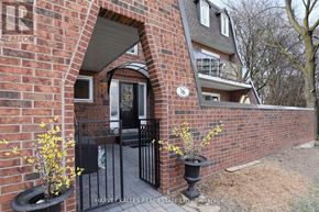 Toronto (Humber Heights) townhouse for rent - A brick house with a black gate and a number 16 on the wall.