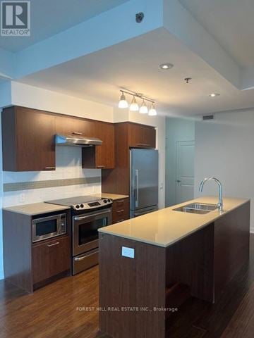 Toronto (Forest Hill South) house for rent - A kitchen with wooden cabinets and a stainless steel refrigerator.