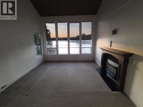 Belcarra apartment for rent - A room with wooden floors and a large window with curtains.