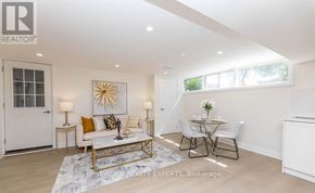 Toronto (West Hill) apartment for rent - A well-lit, spacious living room with a white sofa, a coffee table, and a dining table set up.