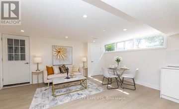 Toronto (West Hill) apartment for rent - A well-lit, spacious living room with a white sofa, a coffee table, and a dining table set up.