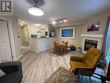 Collingwood condo for rent - A living room with a yellow chair and a fireplace.