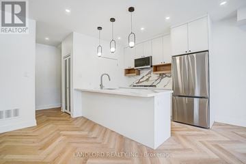 Toronto (Broadview North) fourplex for rent - A kitchen with a white counter and a stainless steel refrigerator.