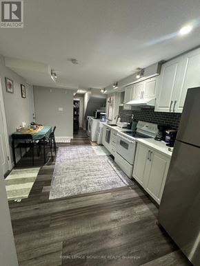 Waterloo apartment for rent - A kitchen with white cabinets and a black tile backsplash.