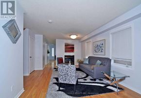 Vaughan (Vellore Village) apartment for rent - A living room with a grey couch, a black and white patterned chair, and a glass coffee table.