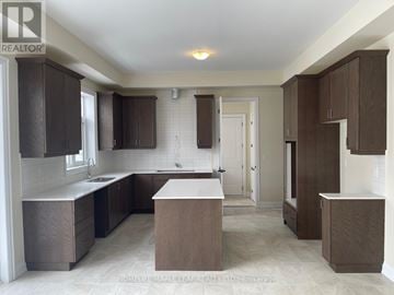 Oro-Medonte apartment for rent - A kitchen with brown cabinets and a white countertop.