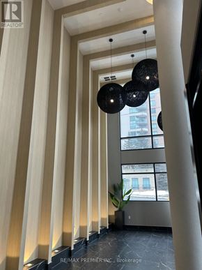 Toronto (Bendale) condo for rent - A hallway with a row of lights on the wall and a plant in a planter.