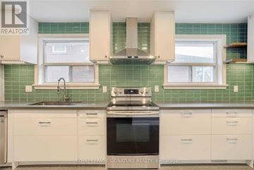 Mississauga (Clarkson) apartment for rent - A kitchen with white cabinets and a green tile backsplash.